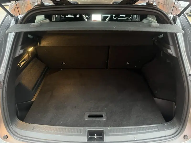 Coffre ouvert vu de l'arrière du Renault Austral blanc, montrant un espace de chargement propre et bien agencé.