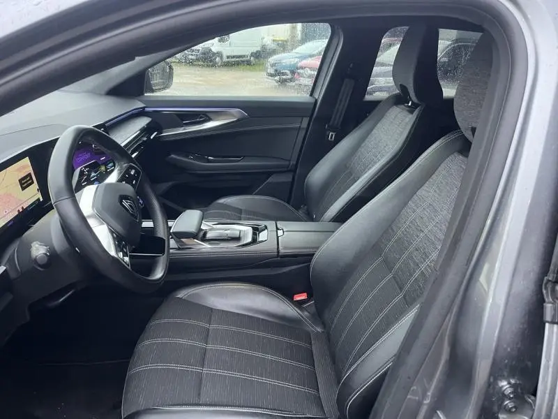 Vue intérieure côté conducteur du Renault Austral 2023 avec sièges gris en similicuir et tableau de bord numérique.