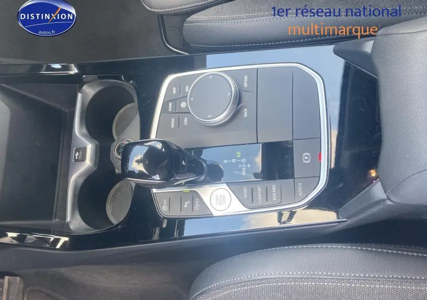 Vue rapprochée de la console centrale noire brillante avec levier de vitesse et commandes d'une BMW Série 1 118i 2023.