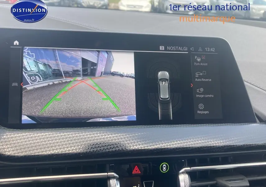 Écran central de BMW Série 1 noir 2023 montrant la caméra de recul avec guidage dynamique en ville.