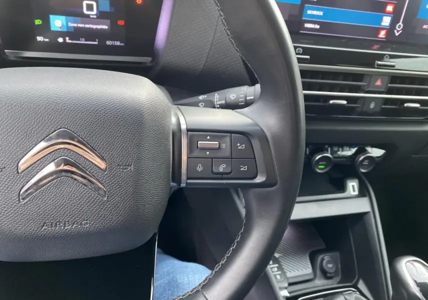 Gros plan sur le volant et la console centrale de la Citroën C4 2021, mettant en valeur les commandes au volant et l'écran tactile.