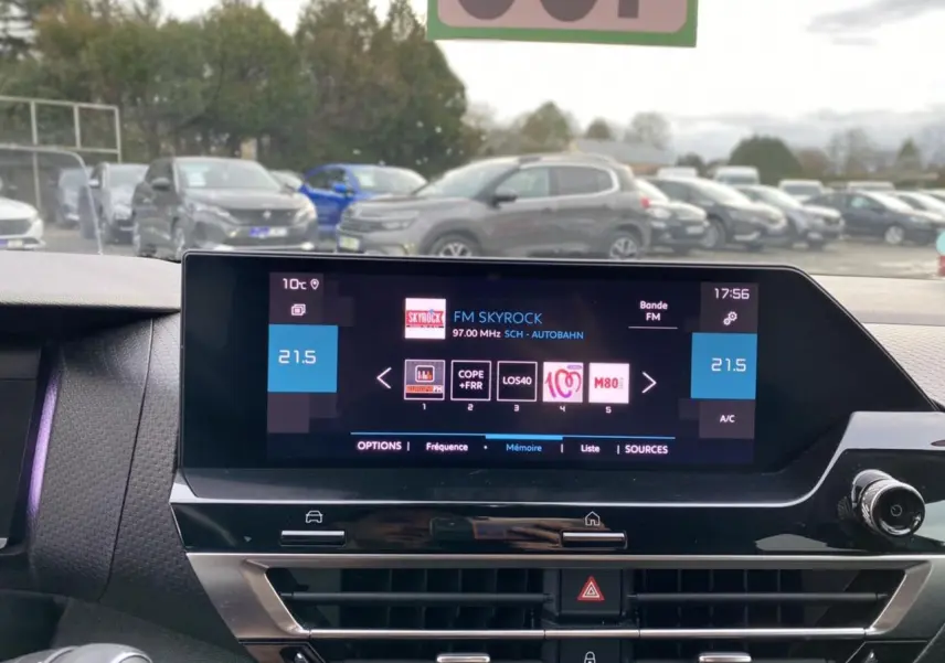 Écran tactile central du tableau de bord d'une Citroën C4 2021, affichant la radio FM Skyrock et la climatisation à 21,5°C.