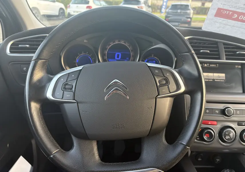 Vue intérieure centrée sur le volant noir de la Citroën C4 II 2.0 HDI 150 HYB avec tableau de bord et écran multimédia.