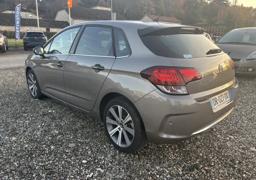 Vue 3/4 arrière droite d'une Citroën C4 gris métallisé de 2015 avec feux arrière LED et jantes alliage.