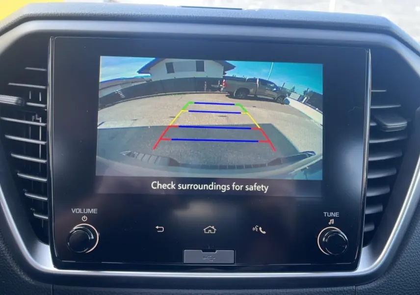 Écran tactile intérieur montrant la caméra de recul du pick-up Isuzu D-MAX gris Kinabalu, vue arrière en stationnement.