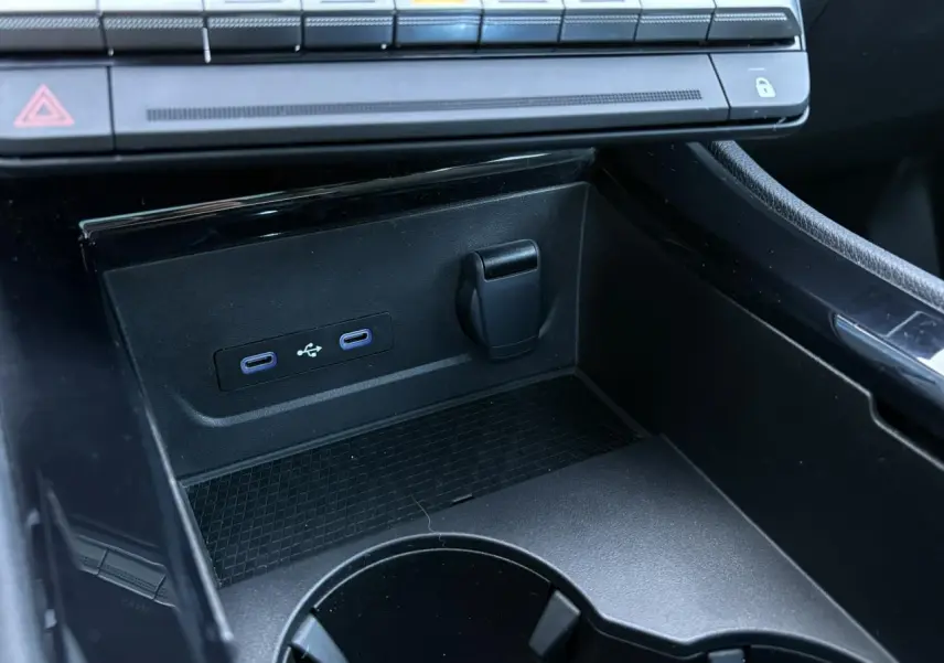 Prise USB double et prise 12V dans la console centrale noire du Renault Austral E-Tech 2024.