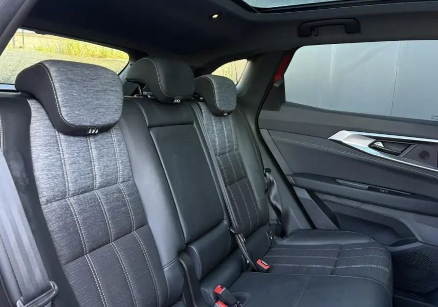 Vue intérieure arrière du Renault Austral E-Tech avec sièges mixte simili-cuir gris et toit panoramique en verre.