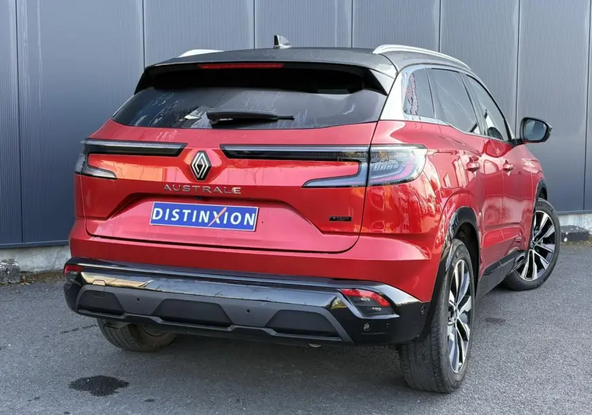 Vue 3/4 arrière droite d'un Renault Austral rouge Flamme avec toit noir étoilé et jantes alliage 19 pouces.