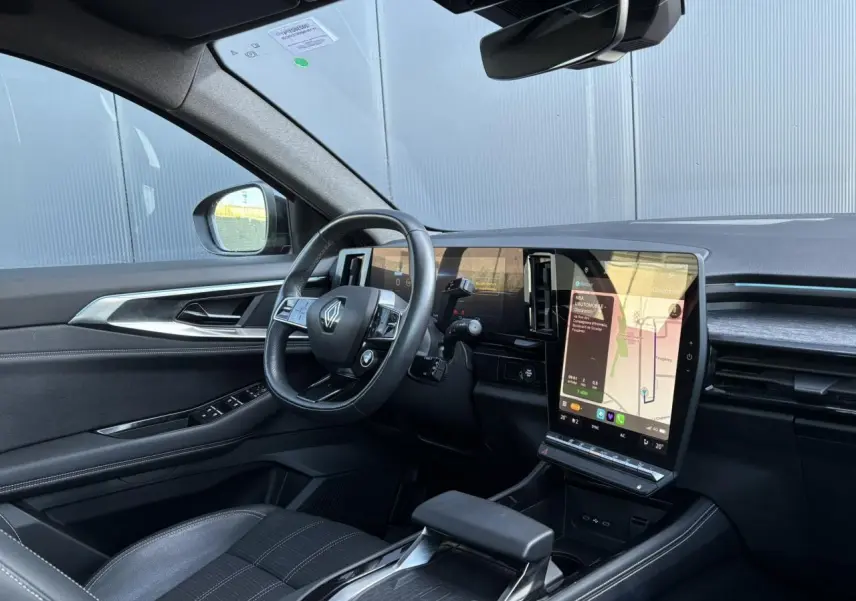 Intérieur côté conducteur du Renault Austral E-Tech 2024, volant cuir, écran tactile vertical et sellerie noire.