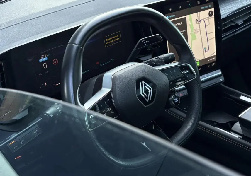 Vue rapprochée du volant cuir et tableau de bord numérique du Renault Austral E-Tech 2024 avec écran tactile central.