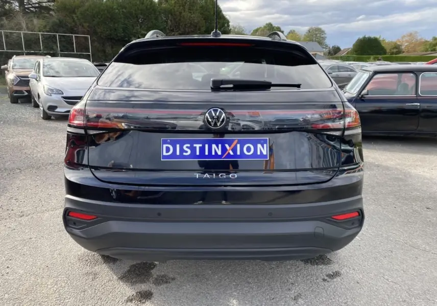 Vue arrière d'un Volkswagen Taigo noir intense avec logo et feux arrière allongés en extérieur.