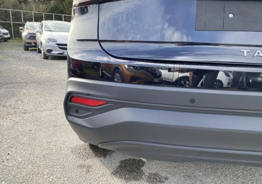 Gros plan sur le pare-chocs arrière noir intense du Volkswagen Taigo 2022 avec capteur de stationnement visible.