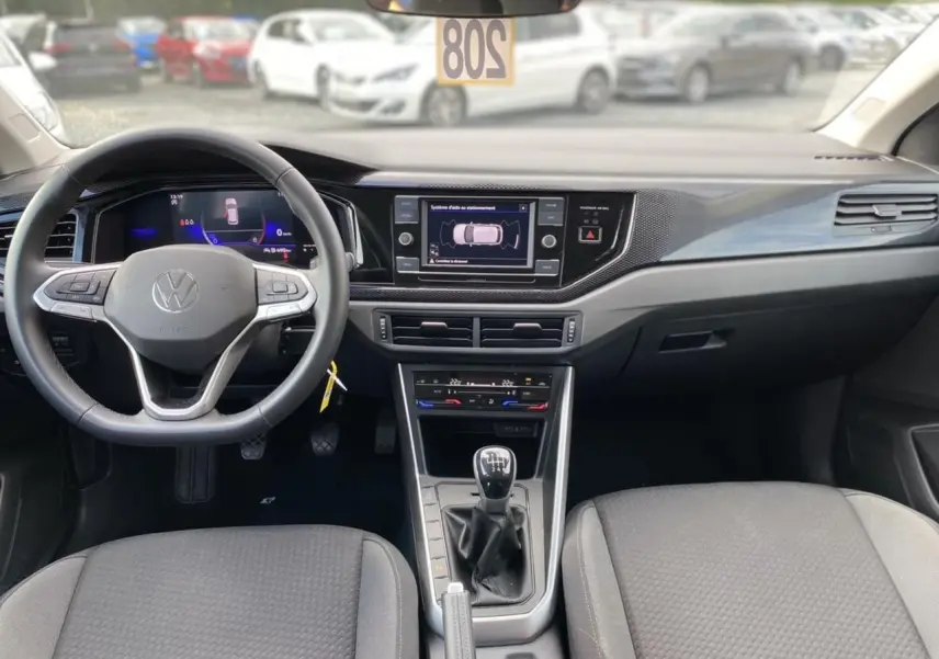 Intérieur de Volkswagen Taigo 2022 noir intense, vue frontale du tableau de bord avec écran tactile et boîte manuelle.