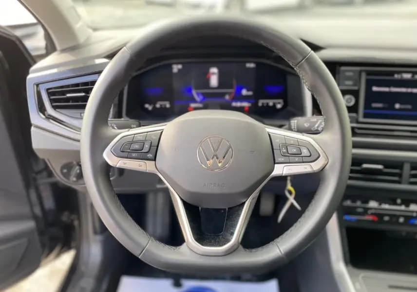Vue rapprochée du volant noir du Volkswagen Taigo 2022 avec commandes intégrées et tableau de bord numérique.