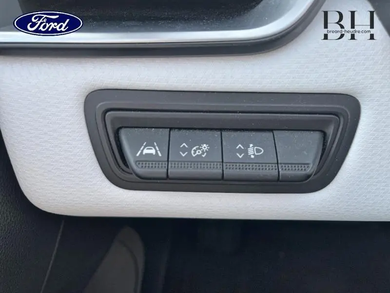 Gros plan sur les commandes d'assistance à la conduite dans l'habitacle de la Renault Clio gris platine 2023.