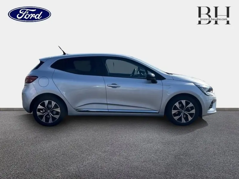 Profil droit d'une Renault Clio 1.6 E-Tech hybride 145ch Evolution gris platine avec jantes alu et vitres arrière surteintées.