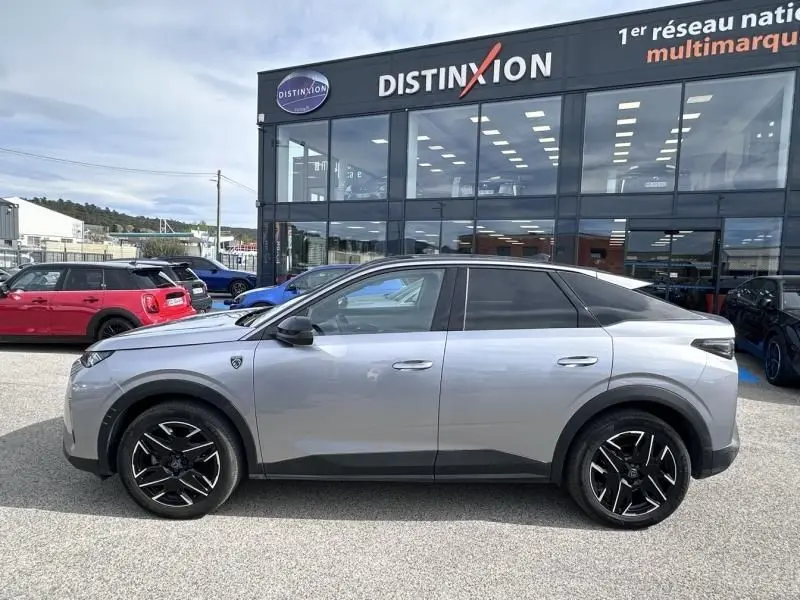Vue de profil côté gauche d'un Peugeot 3008 Nouveau gris métal 2024 hybride avec jantes noires et toit noir.