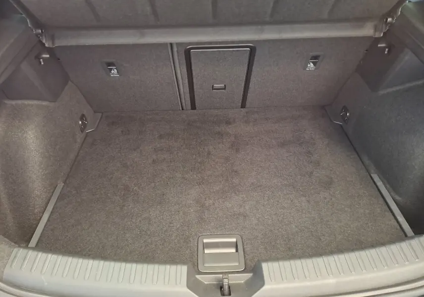 Coffre spacieux et propre de la SEAT LEON 1.5 eTSI Hybrid 2024 en noir minuit, vue intérieure arrière.