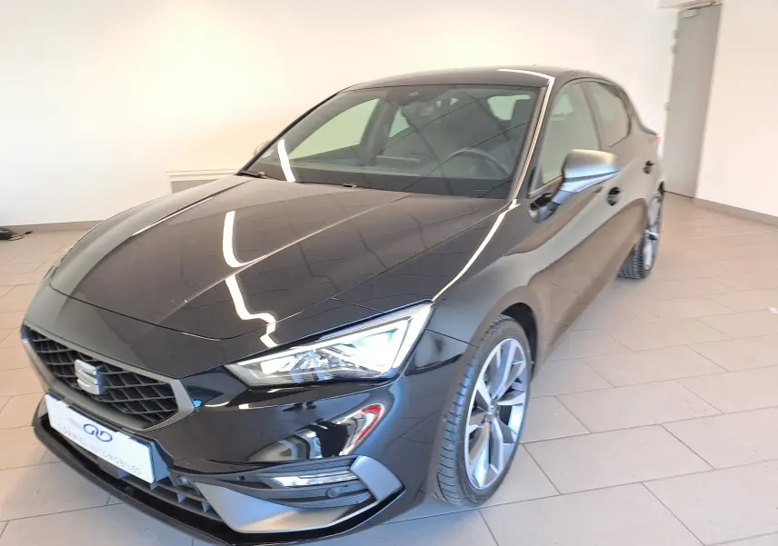 SEAT LEON 1.5 eTSI Hybrid 2024 en noir minuit, vue 3/4 avant droit avec jantes alliage et phares LED.