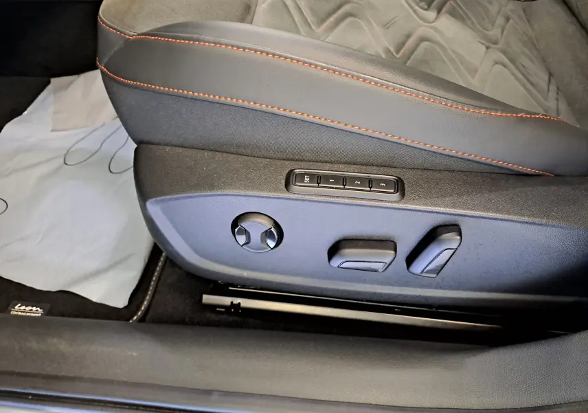 Réglages électriques du siège conducteur noir avec surpiqûres rouges dans une SEAT LEON 2024 côté gauche.
