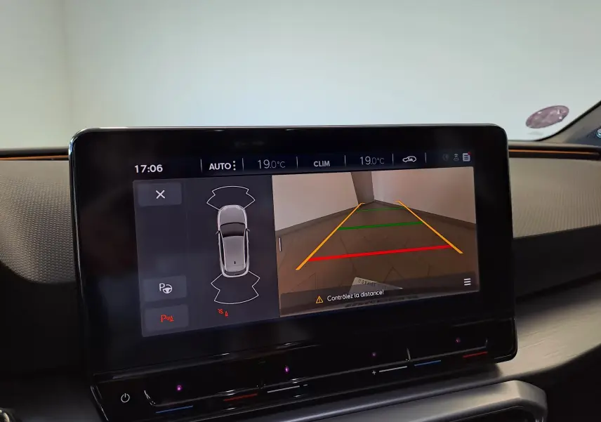 Écran central de la SEAT LEON 2024 affichant la caméra de recul avec guidage coloré et vue du véhicule en plan.