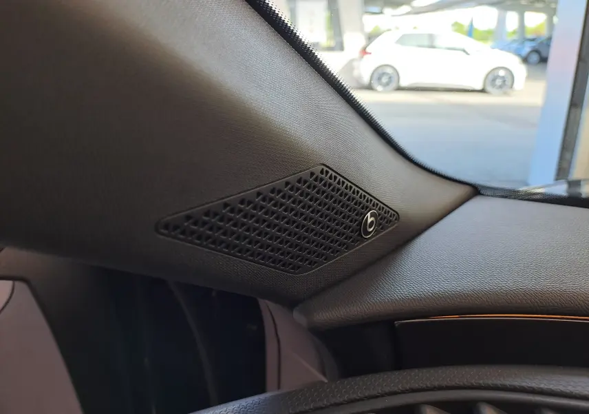 Détail intérieur côté gauche du tableau de bord noir minuit du SEAT LEON 1.5 eTSI Hybrid 2024 avec haut-parleur Beats.