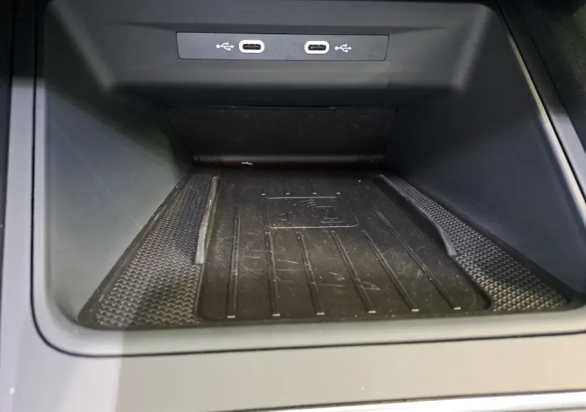 Vue rapprochée du compartiment de recharge sans fil avec deux ports USB-C dans une SEAT LEON 1.5 eTSI Hybrid 2024 noir minuit.
