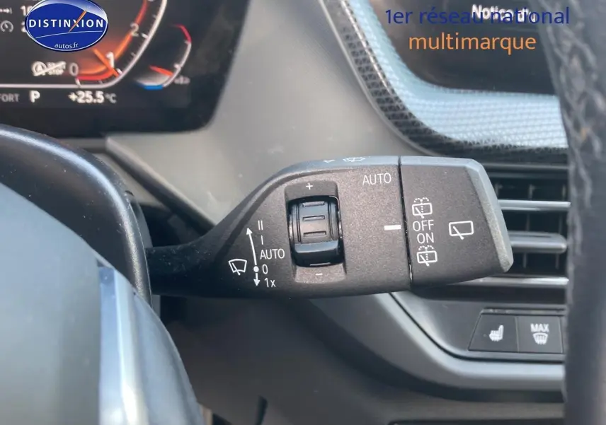 Gros plan sur la commande des essuie-glaces à gauche du volant dans l'habitacle d'une BMW Série 1 gris foncé 2023.