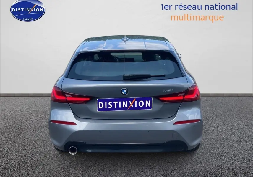 Vue arrière d'une BMW Série 1 118i gris foncé avec feux LED et sortie d'échappement unique côté gauche.