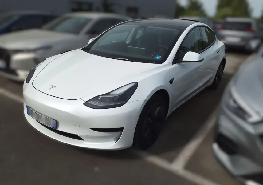 Tesla Model 3 blanc vue 3/4 avant droit, toit panoramique noir et jantes aérodynamiques noires visibles.