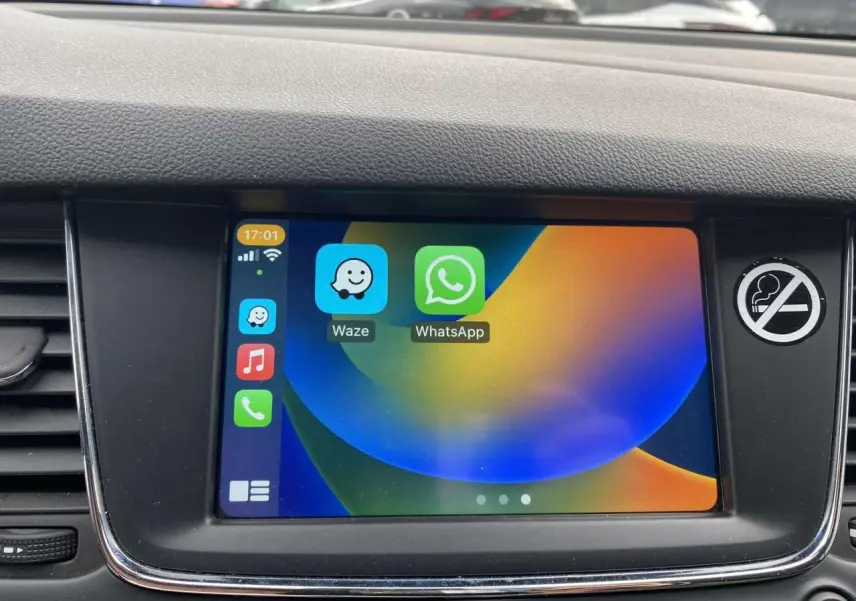 Écran tactile 7 pouces de l'Opel Astra 2021 affichant les applications Waze et WhatsApp, entouré de la console noire.