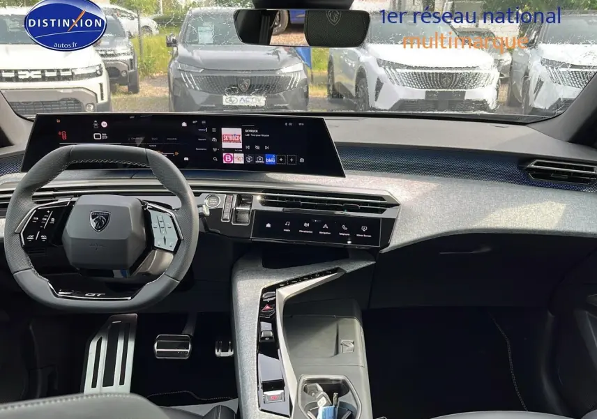 Vue intérieure avant du Peugeot 3008 gris 2025, avec tableau de bord numérique et volant multifonction compact.