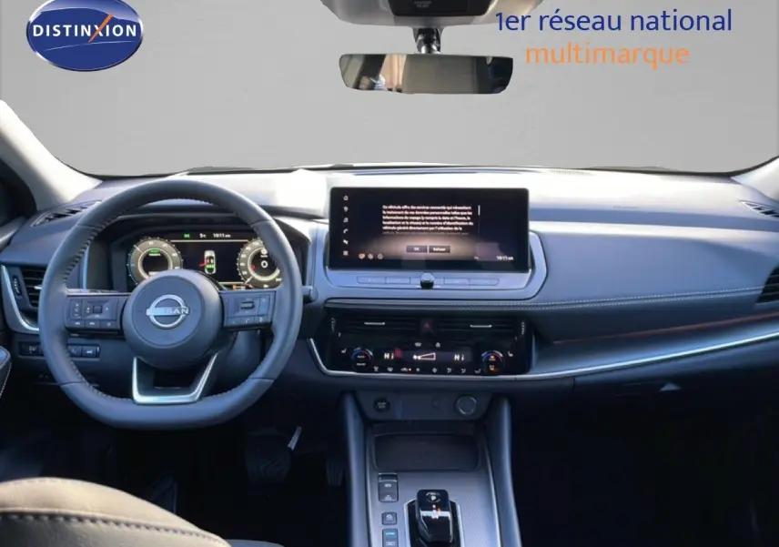 Vue intérieure du tableau de bord et volant du Nissan Qashqai 2025 gris argile métal, avec écran tactile central et commandes modernes.