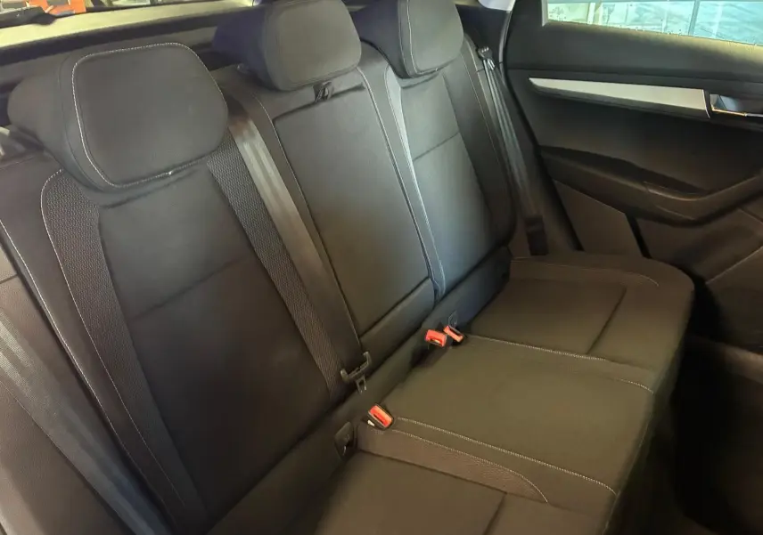 Vue intérieure côté droit des sièges arrière noirs du Skoda Karoq 2023 avec ceintures et appuie-têtes intégrés.