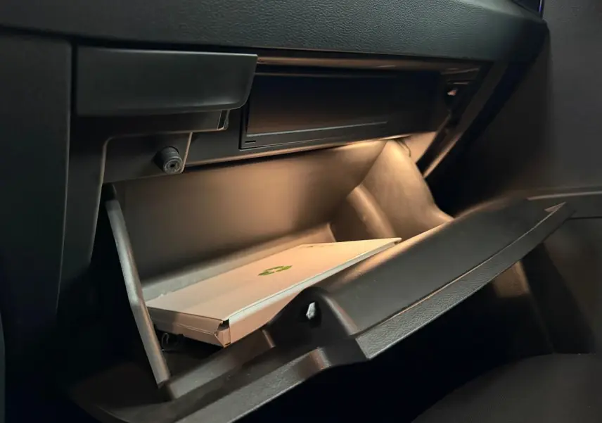 Porte arrière gauche ouverte d’un Skoda Karoq bleu 2023, intérieur noir avec insert décoratif gris clair.