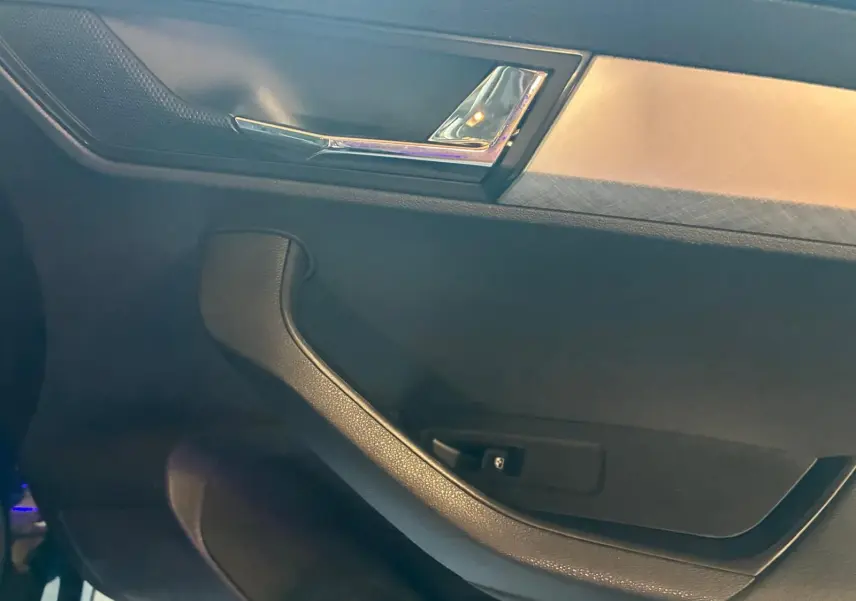 Détail de la poignée de porte intérieure noire avec insert chromé sur Skoda Karoq 2.0 TDI 116 DSG7 Business 2023.