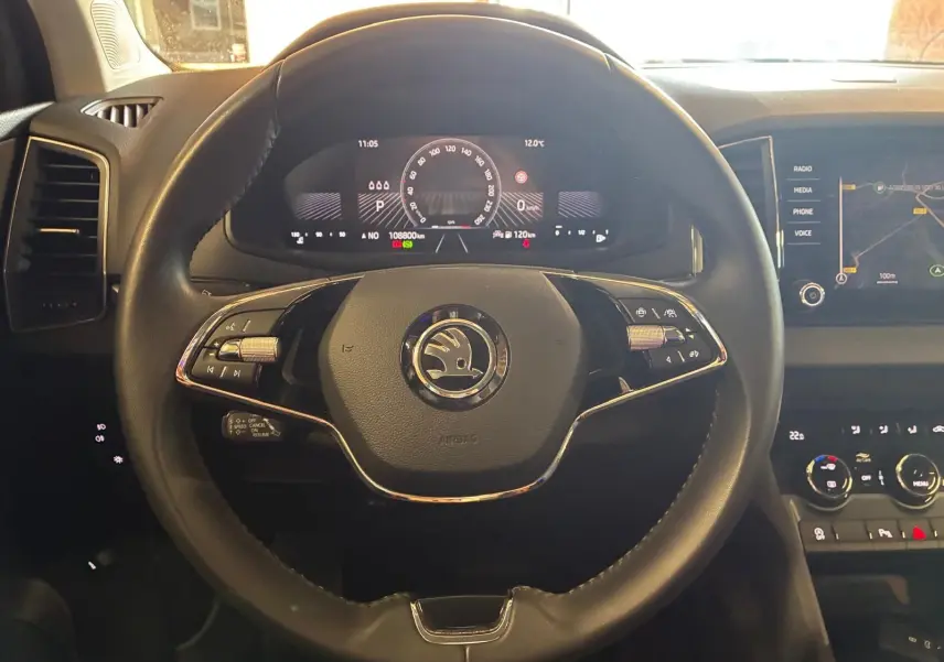 Vue rapprochée du volant noir multifonctions de la Skoda Karoq 2023 avec tableau de bord digital et écran tactile.