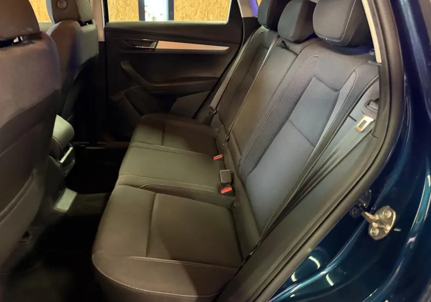 Gros plan sur le volant multifonctions en cuir avec commandes intégrées du Skoda Karoq 2023, intérieur noir.