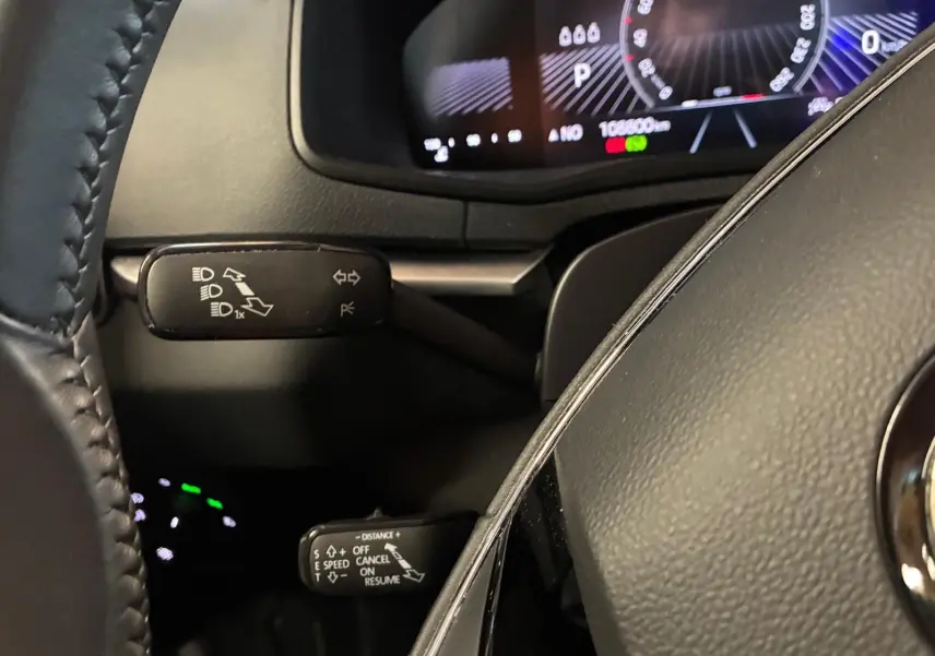 Gros plan sur le volant cuir et les commandes de clignotants et régulateur de vitesse du Skoda Karoq 2023.