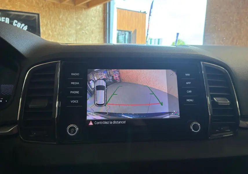 Écran central du Skoda Karoq bleu 2023 montrant la caméra de recul avec guidage de trajectoire.