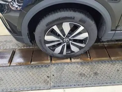 Gros plan sur la roue avant droite gris foncé du Volkswagen T-Roc 2.0 TDI 150 DSG7 LIFE PLUS GOAL 2025 avec jante distinctive.