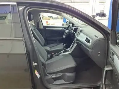 Vue intérieure côté conducteur du Volkswagen T-Roc gris foncé 2025, montrant sièges et tableau de bord moderne.