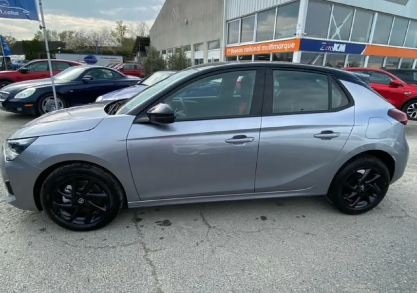 Opel Corsa gris magnetic vue de profil côté gauche, avec toit noir et jantes alliage noires brillantes.