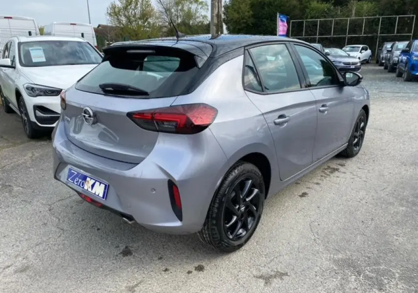 Opel Corsa gris magnetic vue 3/4 arrière droit, toit noir, jantes alliage noires brillantes et feux arrière LED.