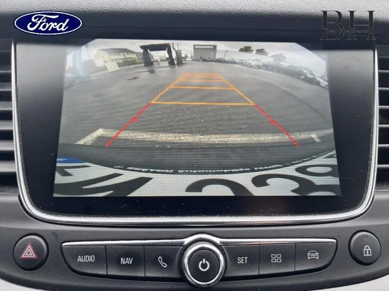 Vue de la caméra de recul sur écran intérieur d'Opel Grandland X gris Quartz avec toit et rétroviseurs noirs.