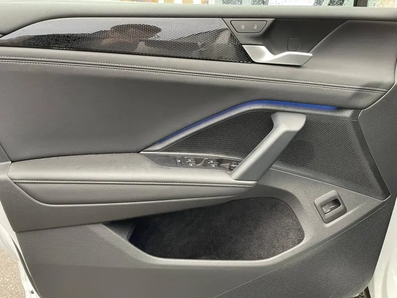 Vue rapprochée de la porte avant gauche noire du Volkswagen Tiguan 2025 avec commandes de vitres et verrouillage.