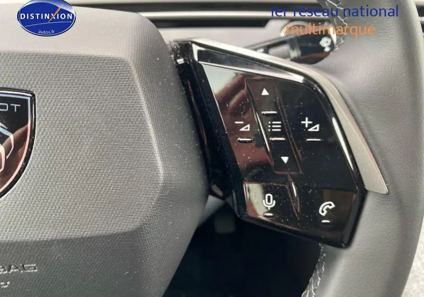 Gros plan sur les commandes multifonctions noires du côté droit du volant cuir d'une Peugeot 3008 bleu 2025.