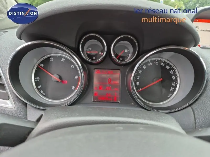 Vue rapprochée du tableau de bord et des compteurs de l'Opel Mokka 2015 avec affichage numérique rouge.