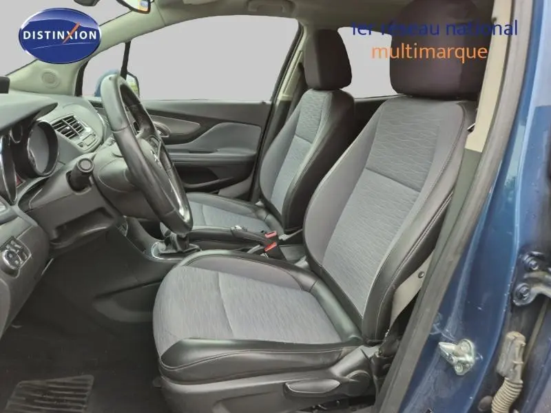 Vue intérieure côté gauche de l’Opel Mokka bleu outremer, montrant les sièges avant en tissu et cuir noir.