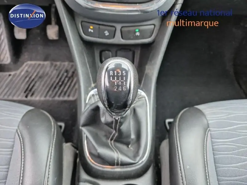 Gros plan sur le levier de vitesses manuel noir de l’Opel Mokka 2015, entouré des sièges avant en tissu gris.